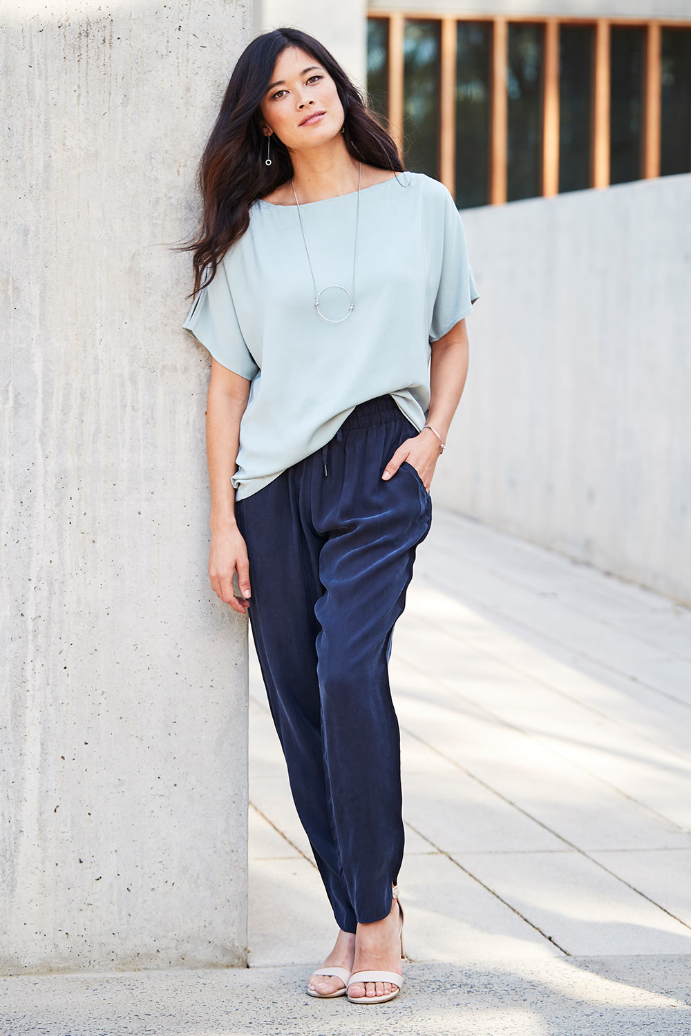Model Miranda wearing size 10 of The Curve Hem Pant in colour Ink (Blue), from the front, showing the whole outfit