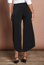Model Madeline wearing size 10 of The Cross Over Pant in colour Black (Black), from the back