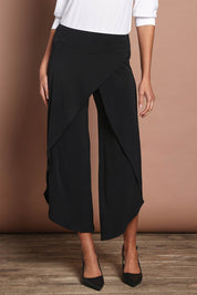 Model Madeline wearing size 10 of The Cross Over Pant in colour Black (Black), from the front, cropped image