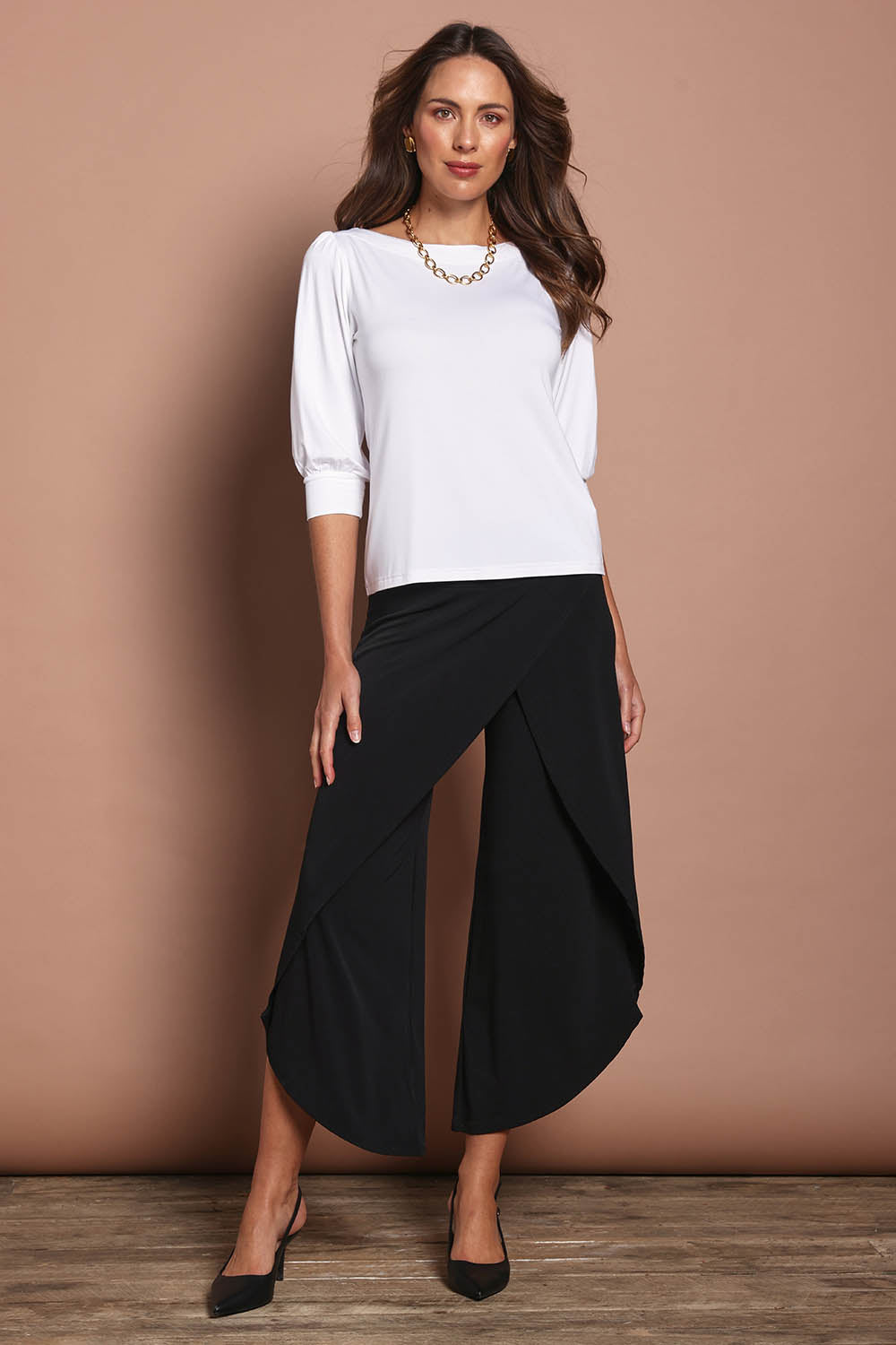 Model Madeline wearing size 10 of The Cross Over Pant in colour Black (Black), from the front, showing the whole outfit