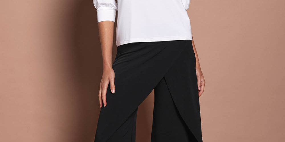 Model Madeline wearing size 10 of The Cross Over Pant in colour Black (Black), from the front, showing the whole outfit