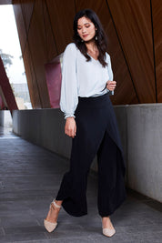 Model Miranda wearing size 10 of The Cross Over Pant in colour Black (Black), from the front, showing the whole outfit