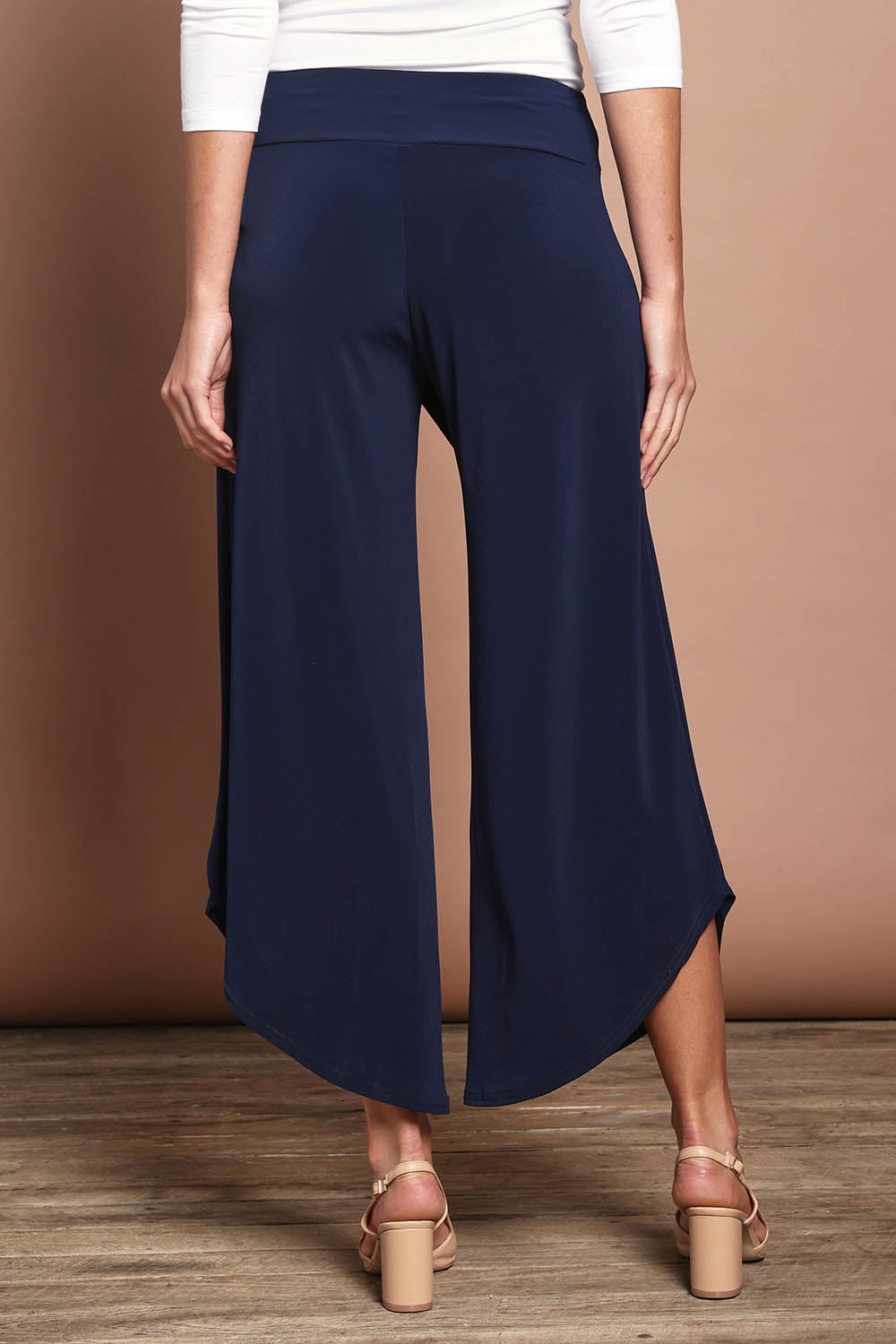 Model Madeline wearing size 10 of The Cross Over Pant in colour Navy (Blue), from the back