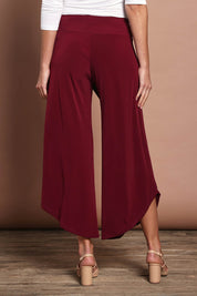 Model Madeline wearing size 10 of The Cross Over Pant in colour Port (Purple), from the back