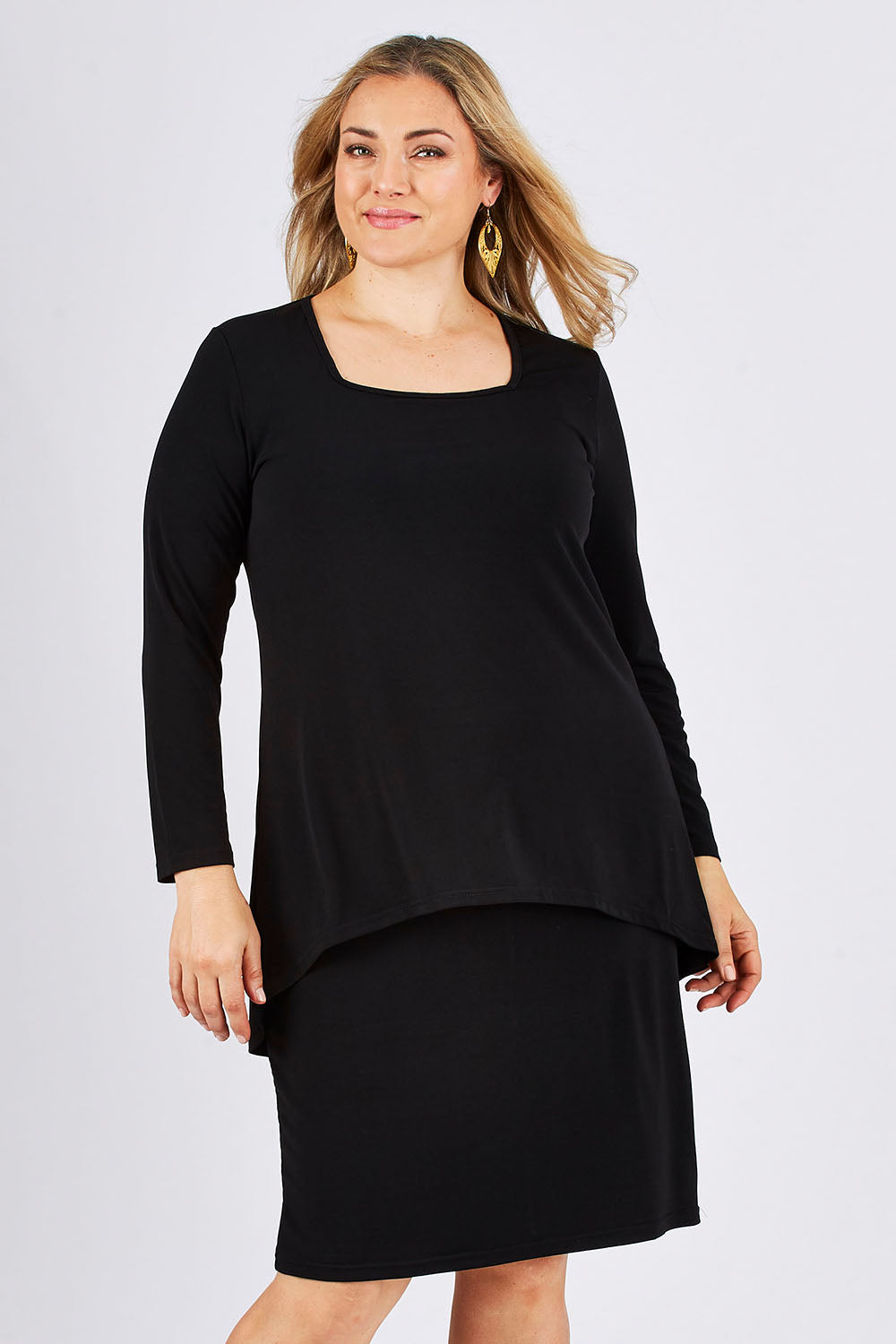Model Ljubenka wearing size 18 of The Long Rita Dress in colour Black (Black), from the front, cropped image