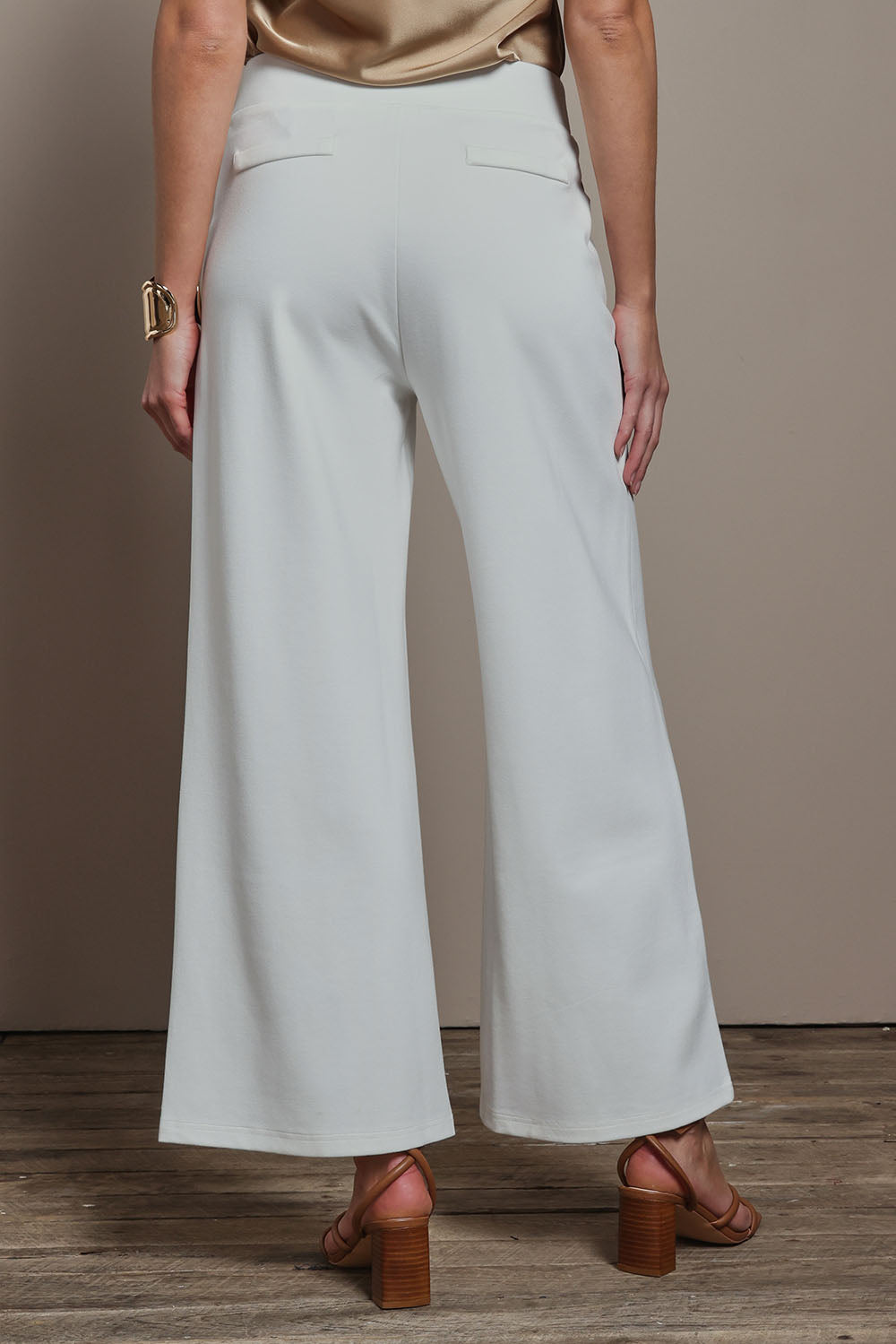 Model Madeline wearing size 10 of The Wide Leg Ponte Pant in colour Pearl (White), from the back