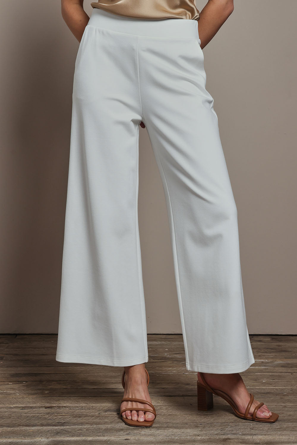 Model Madeline wearing size 10 of The Wide Leg Ponte Pant in colour Pearl (White), from the front, cropped image
