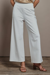 Model Madeline wearing size 10 of The Wide Leg Ponte Pant in colour Pearl (White), from the front, cropped image