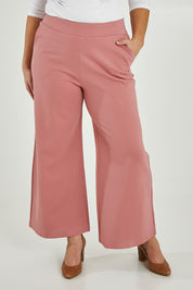 Model Maddy wearing size 16 of The Wide Leg Ponte Pant in colour Rose (Pink), from the front, cropped image