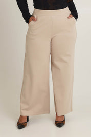 Model Ashleigh wearing size 16 of The Wide Leg Ponte Pant in colour Sand, from the front, cropped image