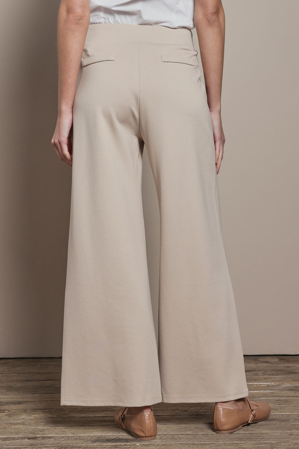 Model Madeline wearing size 10 of The Wide Leg Ponte Pant in colour Sand, from the back