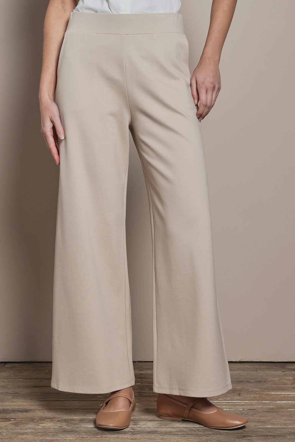 Model Madeline wearing size 10 of The Wide Leg Ponte Pant in colour Sand, from the front, cropped image