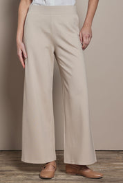 Model Madeline wearing size 10 of The Wide Leg Ponte Pant in colour Sand, from the front, cropped image