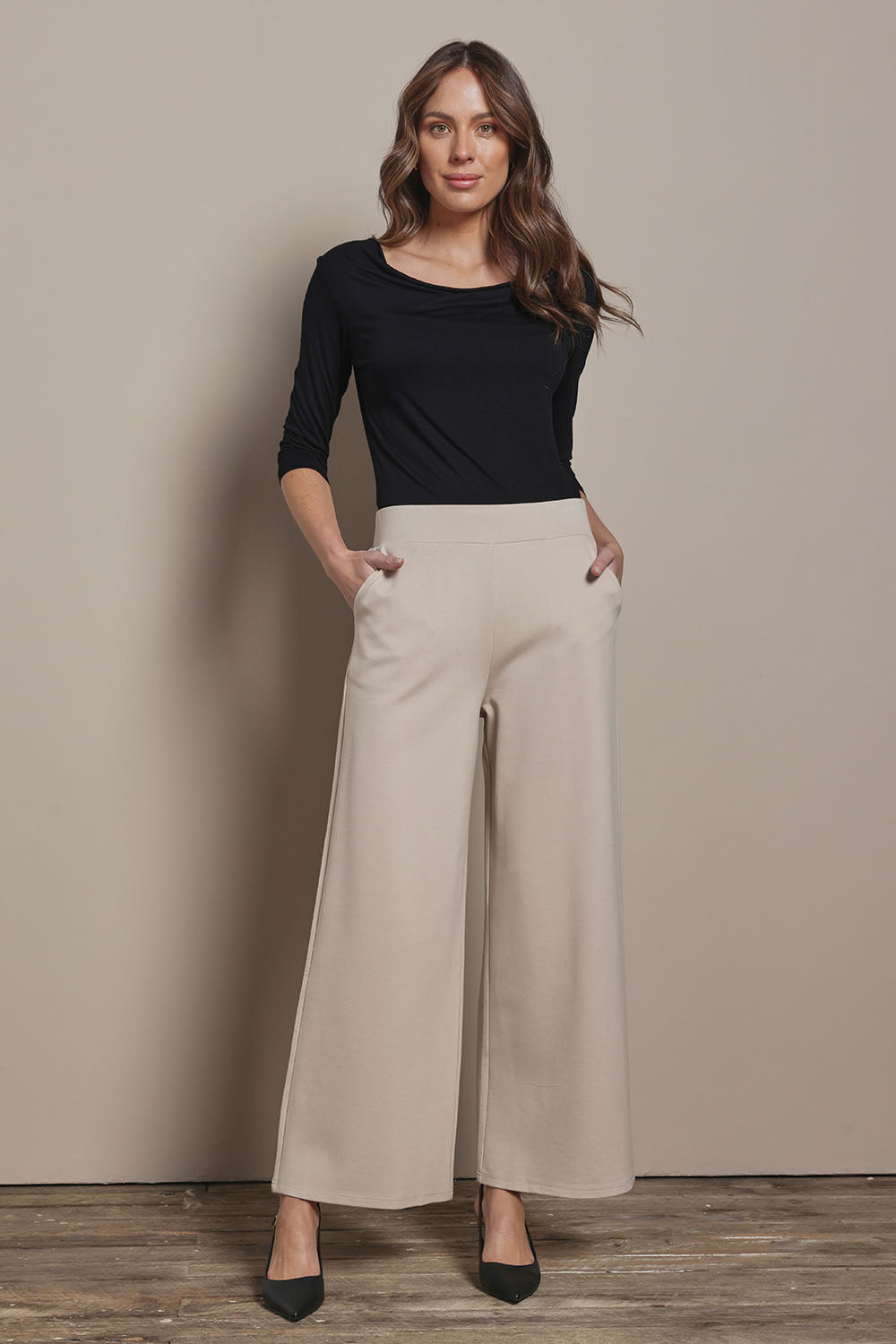 Model Madeline wearing size 10 of The Wide Leg Ponte Pant in colour Sand, from the front, showing the whole outfit