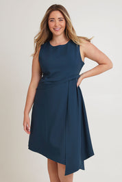 Model Chanel wearing size 16 of The Side Pleated Dress in colour Deepocean (Blue), from the front, cropped image