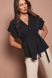 Model Madeline wearing size 10 of The Kimono Top in colour Black (Black), from the front, cropped image
