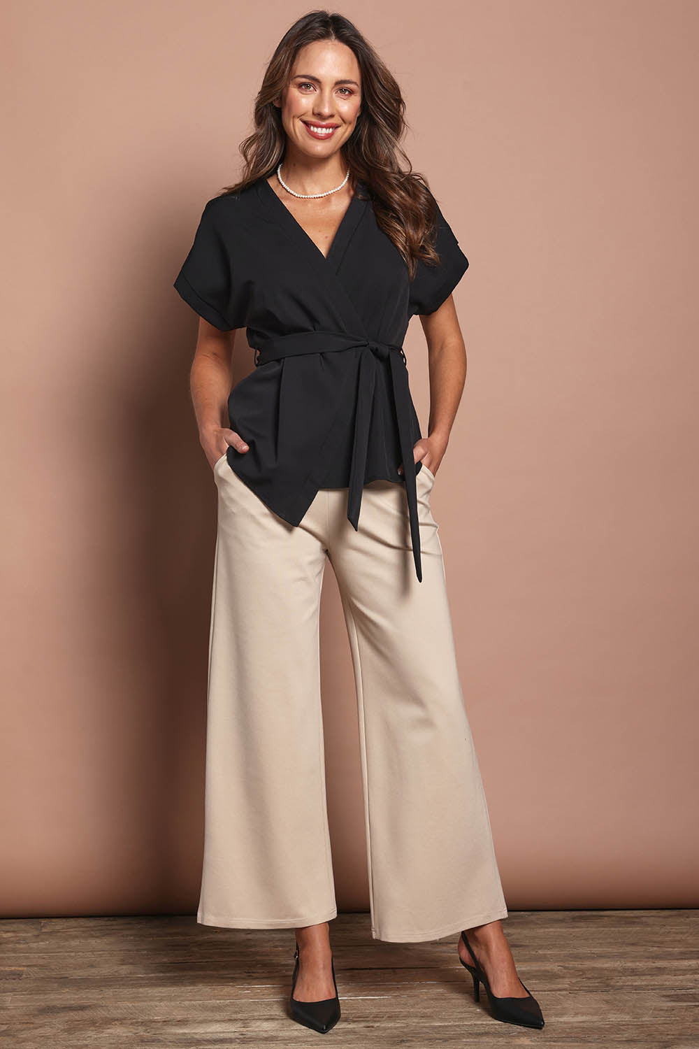 Model Madeline wearing size 10 of The Kimono Top in colour Black (Black), from the front, showing the whole outfit
