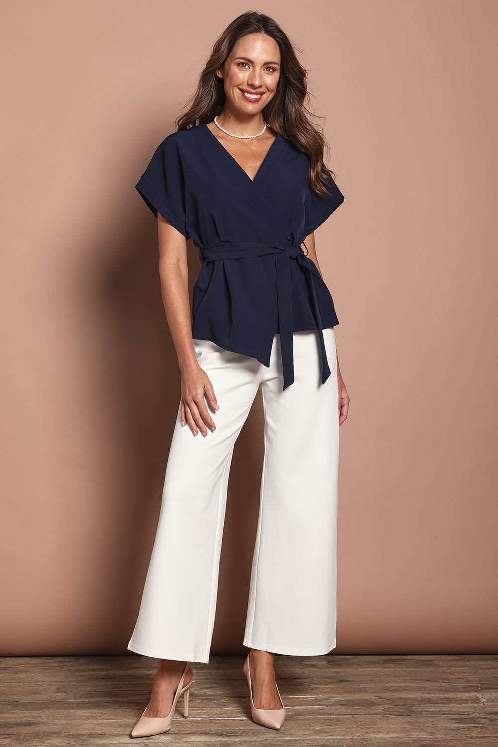 Model Madeline wearing size 10 of The Kimono Top in colour Navy (Blue), from the front, showing the whole outfit