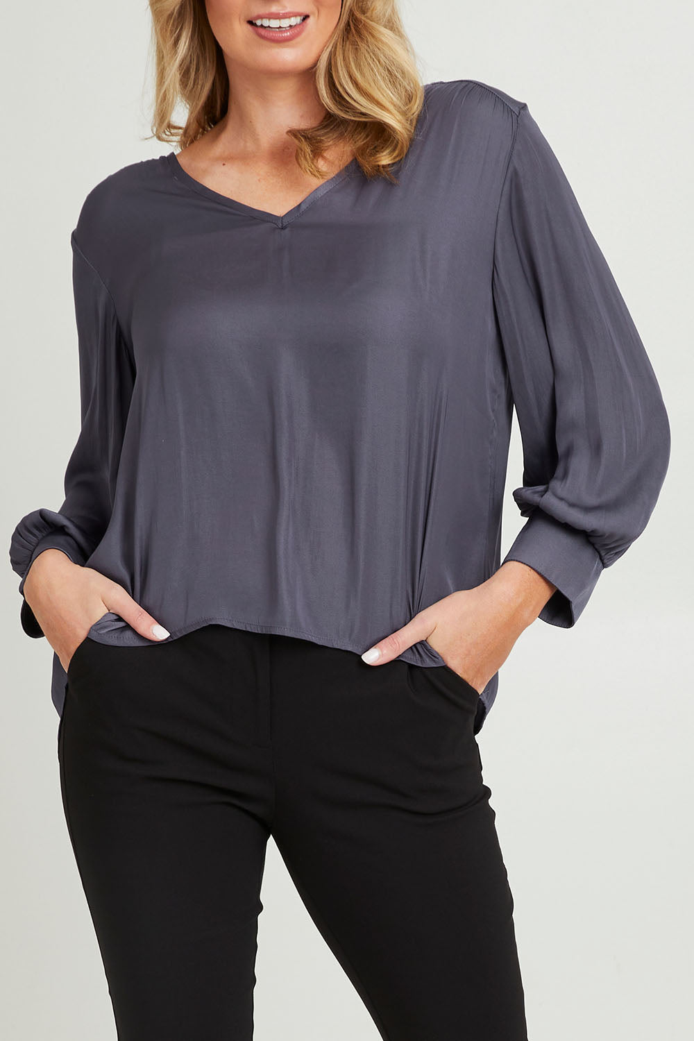 Model Grace wearing size 10 of The Luxe V Neck Blouse in colour Slate (Grey), from the front, cropped image