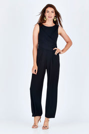Model Rebecca wearing size 10 of The Cross Waist Jumpsuit in colour Black (Black), from the front, showing the whole outfit