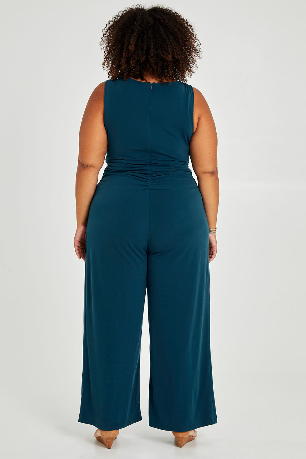 Model Alexis wearing size 18 of The Cross Waist Jumpsuit in colour Darkteal (Green), from the back