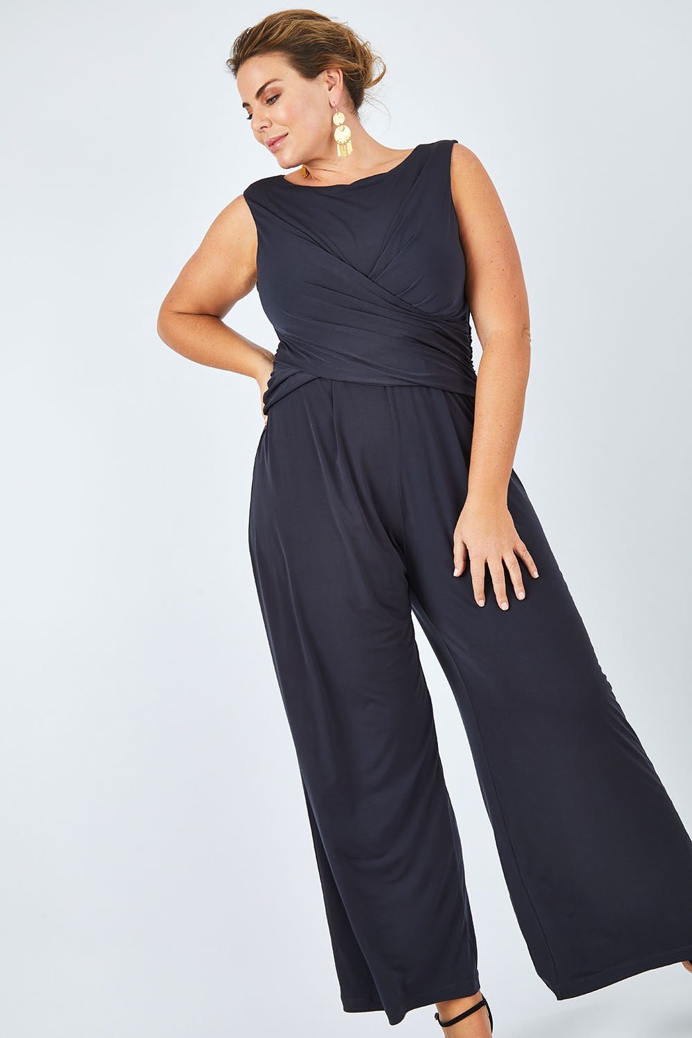 Model Fiona wearing size 16 of The Cross Waist Jumpsuit in colour Graphite (Grey), from the front, showing the whole outfit