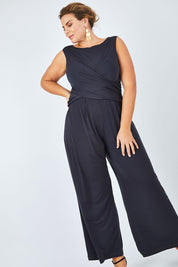 Model Fiona wearing size 16 of The Cross Waist Jumpsuit in colour Graphite (Grey), from the front, showing the whole outfit