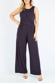 Model Jess wearing size 14 of The Cross Waist Jumpsuit in colour Graphite (Grey), from the front, cropped image