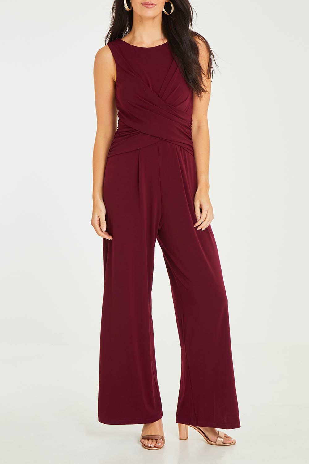 Model Stacey wearing size 10 of The Cross Waist Jumpsuit in colour Port (Purple), from the front, cropped image