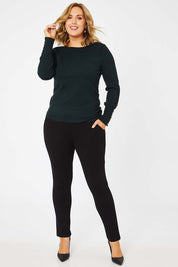 Model Jess wearing size L of The Boat Neck Knit in colour Darkpine (Green), from the front, showing the whole outfit