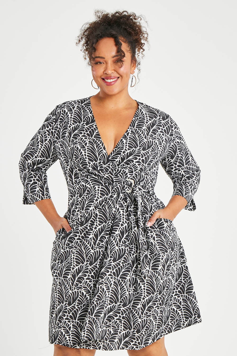 Model Alexis wearing size 16 of The Define Printed Wrap Dress in colour Fern (Black), from the front, cropped image