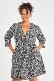 Model Alexis wearing size 16 of The Define Printed Wrap Dress in colour Fern (Black), from the front, cropped image