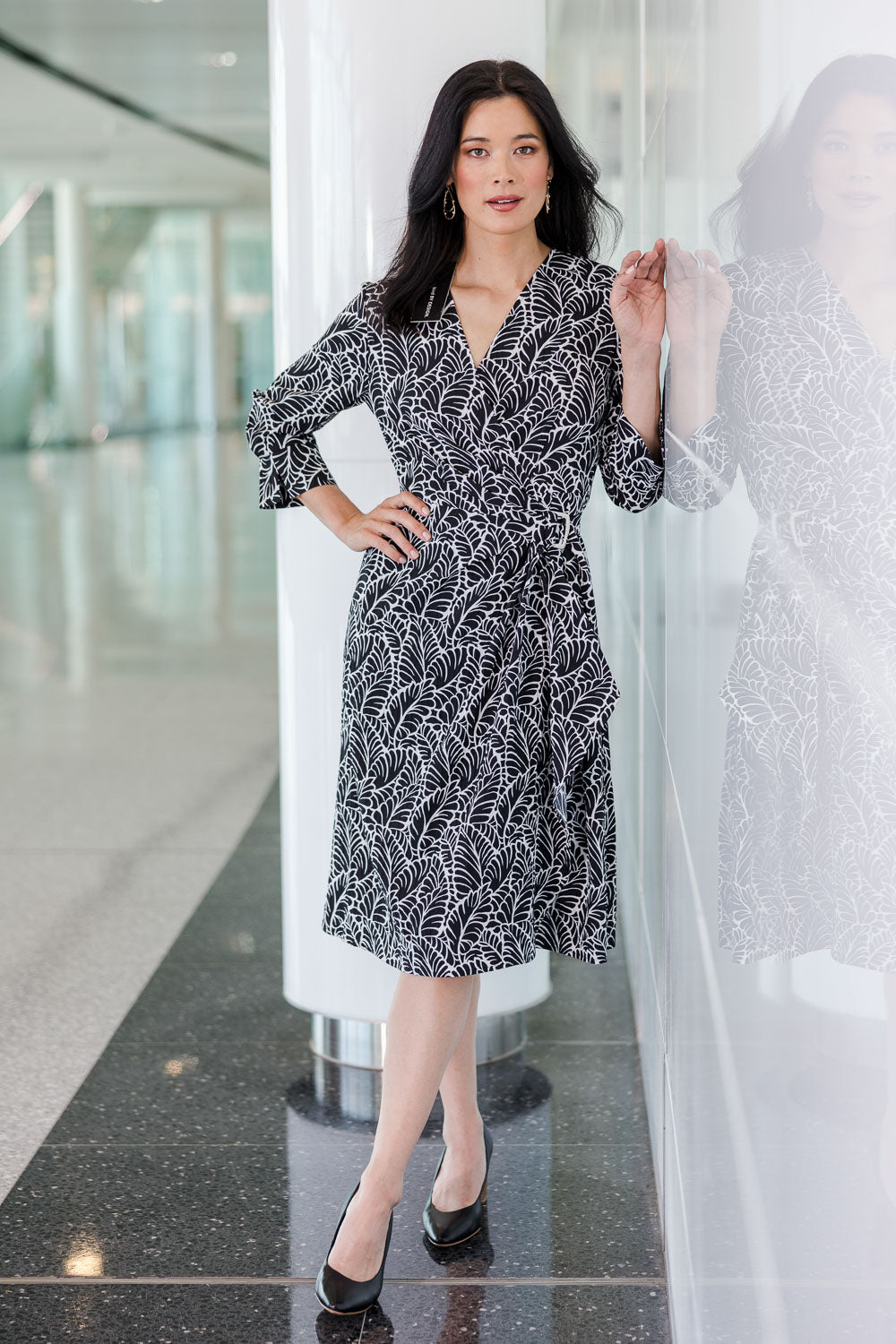 Model Miranda wearing size 10 of The Define Printed Wrap Dress in colour Fern (Black), from the front, showing the whole outfit