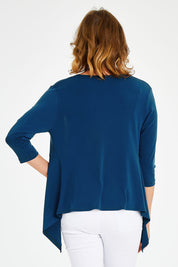Model Naomi wearing size 10 of The Drape Cardi in colour Ocean (Blue), from the back