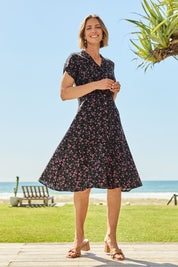 Model Riina wearing size 10 of The Printed Cotton V Neck Dress in colour Ditsy (Black), from the front, showing the whole outfit