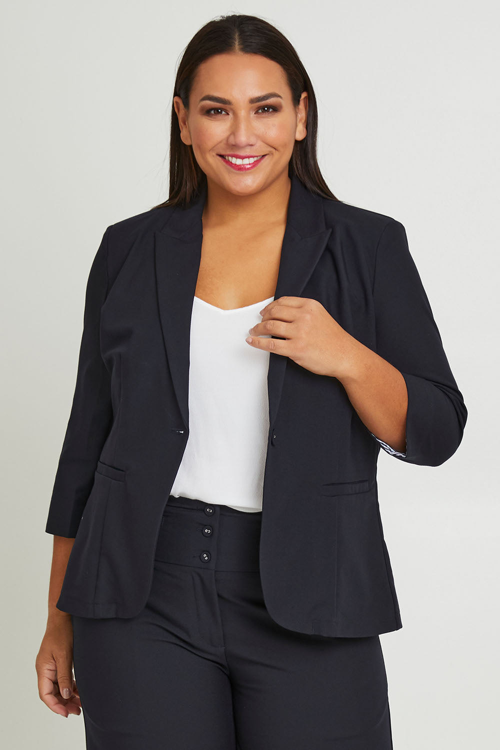 Model Ashleigh wearing size 16 of The Contrast Inner Cuff Blazer in colour Ink (Blue), from the front, cropped image