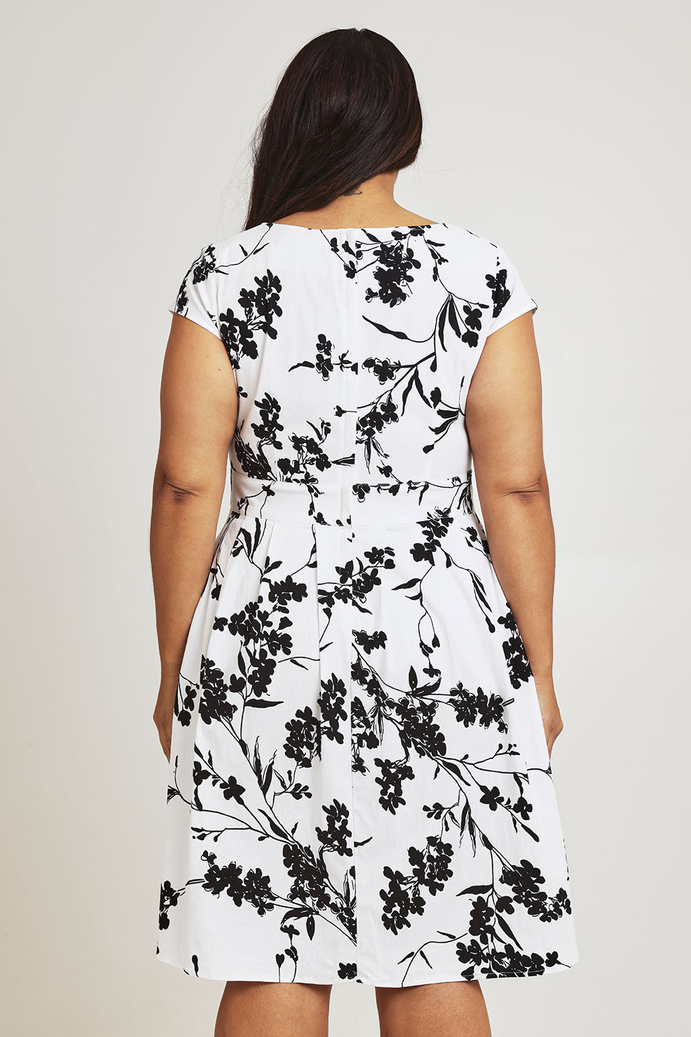 Model Ashleigh wearing size 16 of The Pleated Cotton Stretch Dress in colour Monofleur (White), from the back