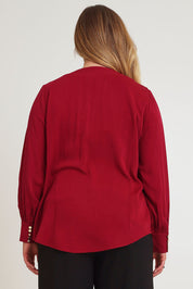 Model Chanel wearing size 16 of The Button Detail Cuff Blouse in colour Garnet (Red), from the back