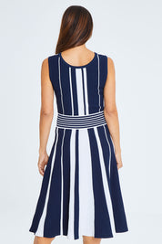 Model Cara wearing size S of The Reversible Knit Dress in colour Navystripe (Blue), from the back