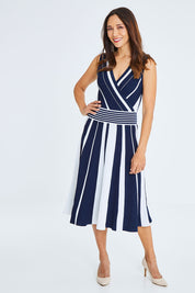 Model Cara wearing size S of The Reversible Knit Dress in colour Navystripe (Blue), from the front, showing the whole outfit