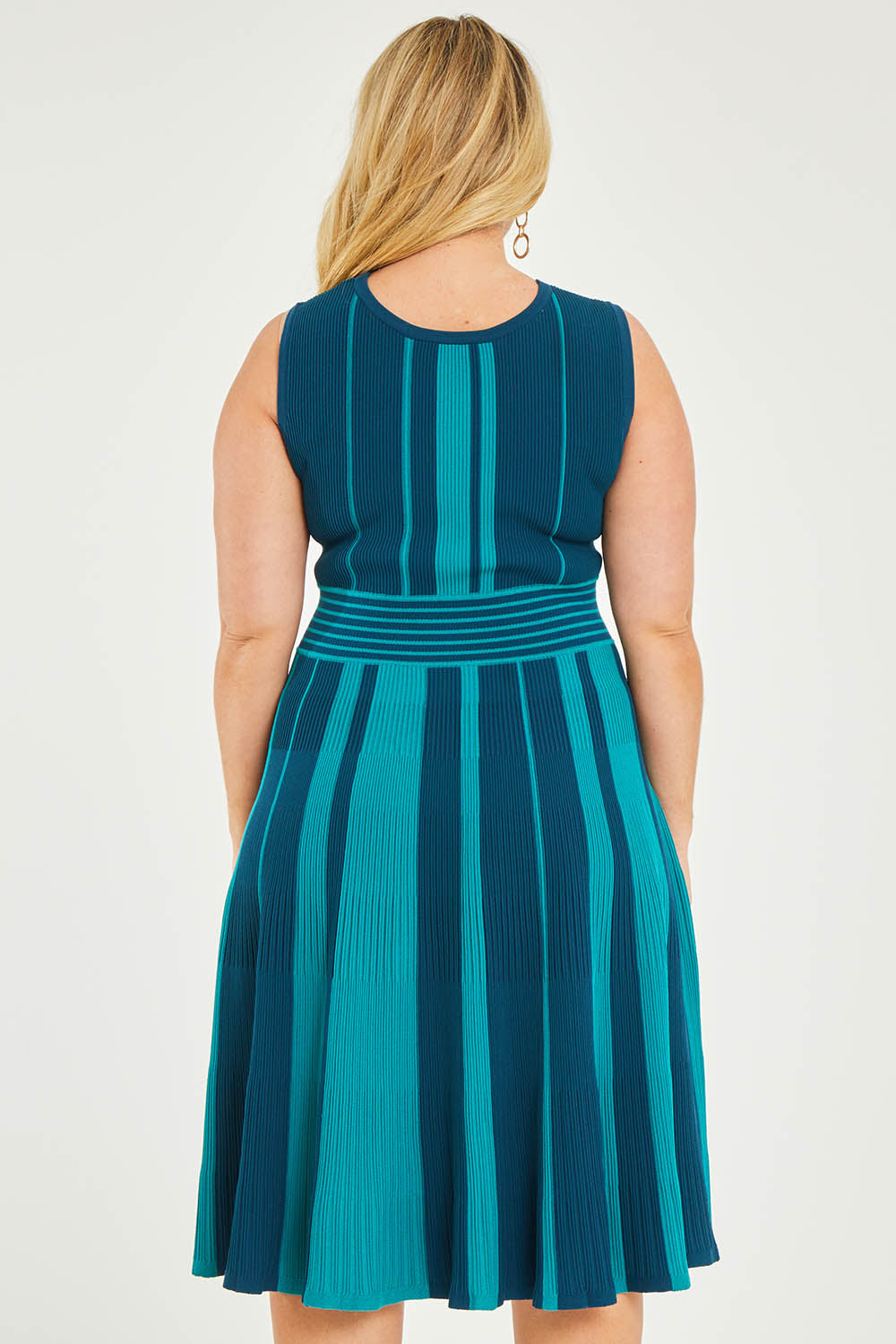 Model Katie wearing size XL of The Reversible Knit Dress in colour Peacock (Blue), from the back