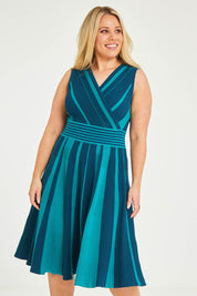 Model Katie wearing size XL of The Reversible Knit Dress in colour Peacock (Blue), from the front, cropped image