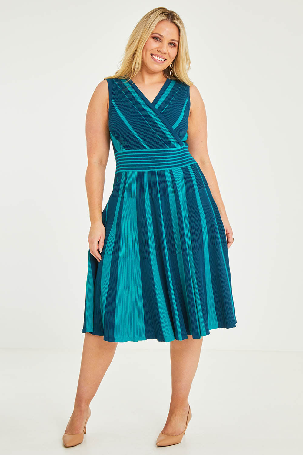 Model Katie wearing size XL of The Reversible Knit Dress in colour Peacock (Blue), from the front, showing the whole outfit