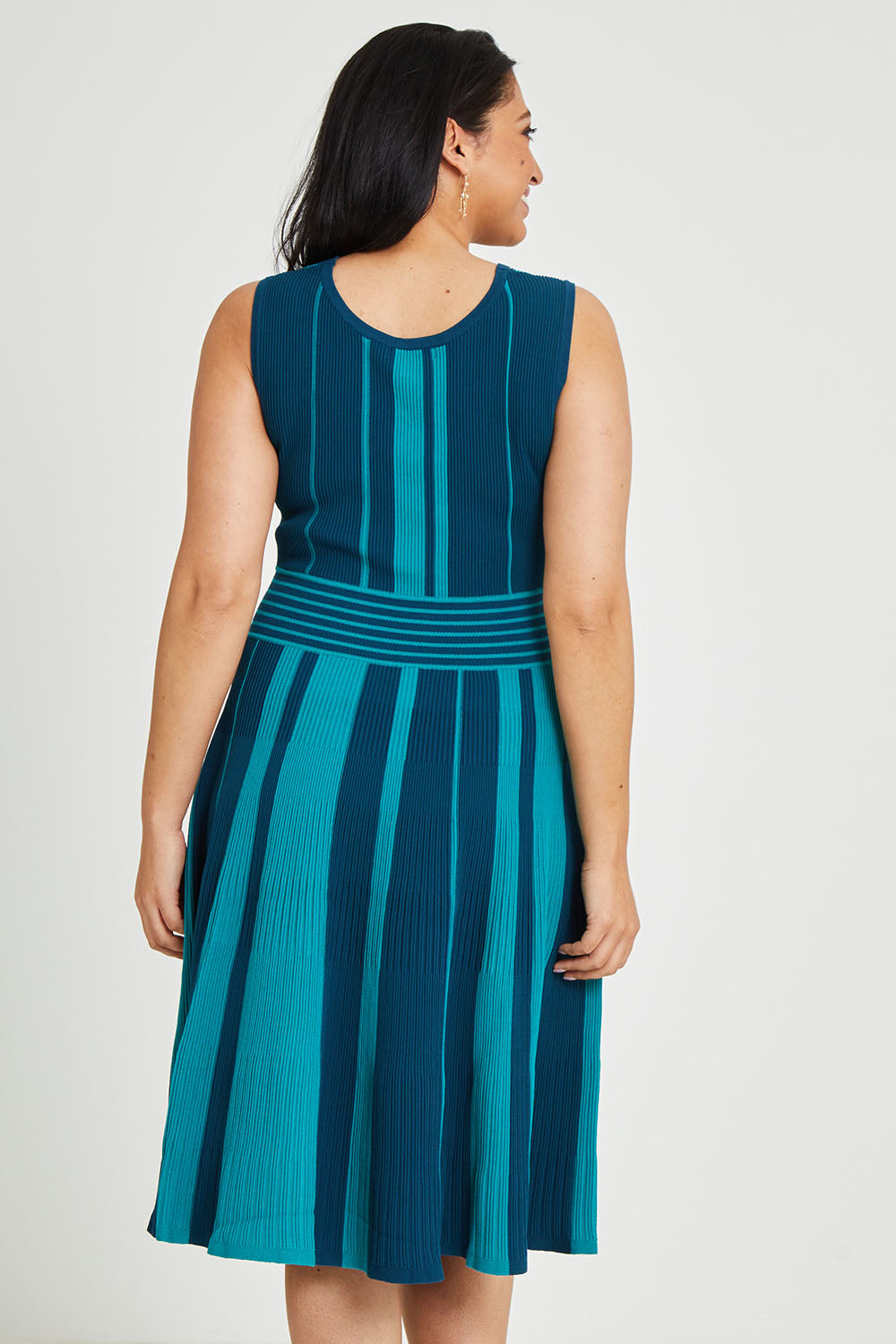 Model Terri-Leigh wearing size L of The Reversible Knit Dress in colour Peacock (Blue), from the back