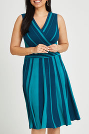 Model Terri-Leigh wearing size L of The Reversible Knit Dress in colour Peacock (Blue), from the front, cropped image