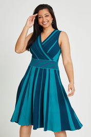 Model Terri-Leigh wearing size L of The Reversible Knit Dress in colour Peacock (Blue), from the front, cropped image