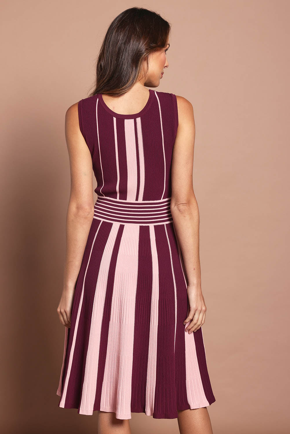 Model Madeline wearing size S of The Reversible Knit Dress in colour Plumstripe (Purple), from the back