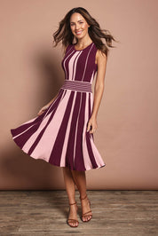 Model Madeline wearing size S of The Reversible Knit Dress in colour Plumstripe (Purple), from the front, showing the whole outfit