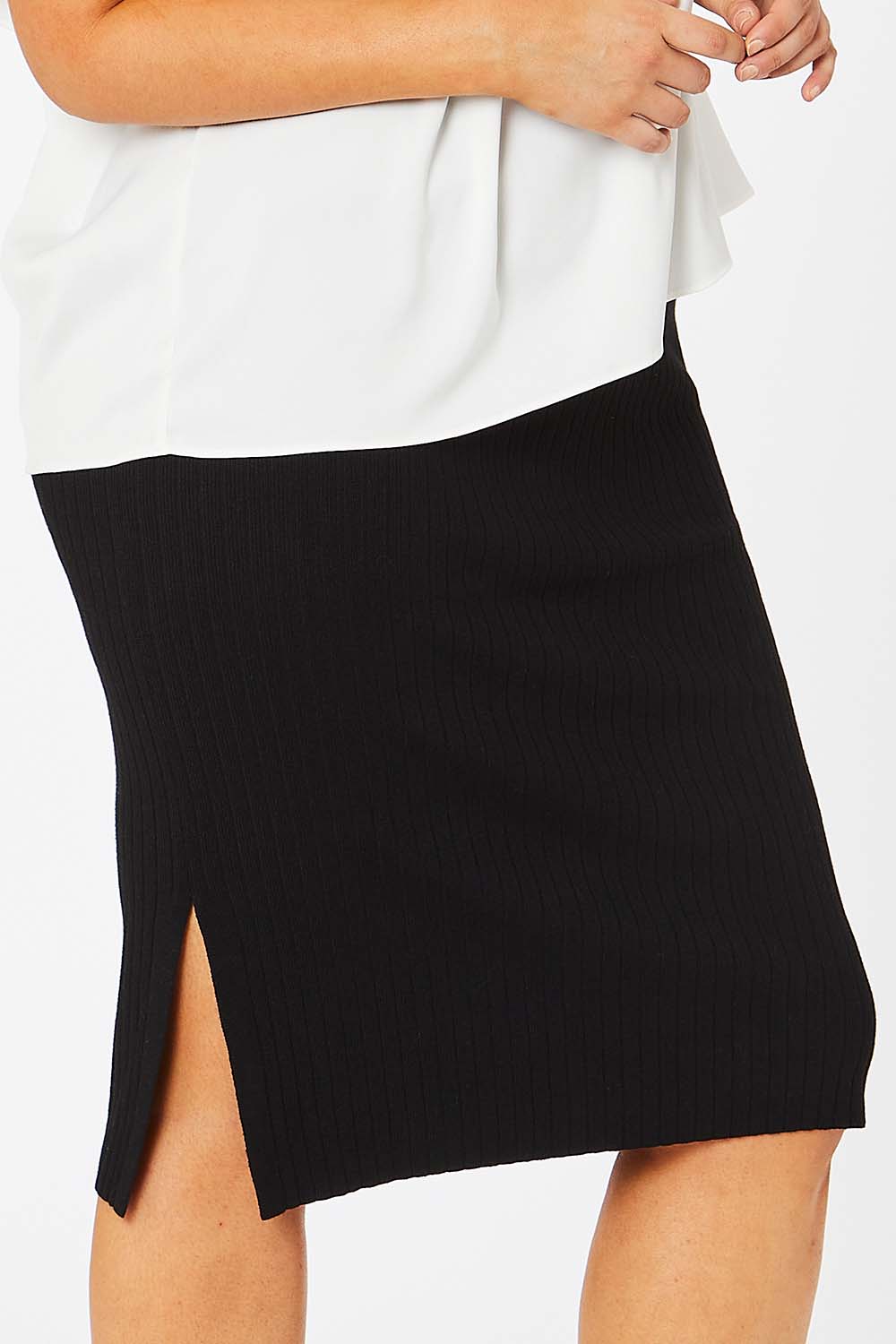 Model Jess wearing size L of The Ribbed Knit Skirt in colour Black (Black), from the front, cropped image