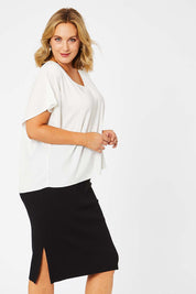 Model Jess wearing size L of The Ribbed Knit Skirt in colour Black (Black), from the front, cropped image